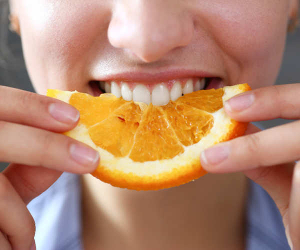 Femme mangeant un quartier d'orange